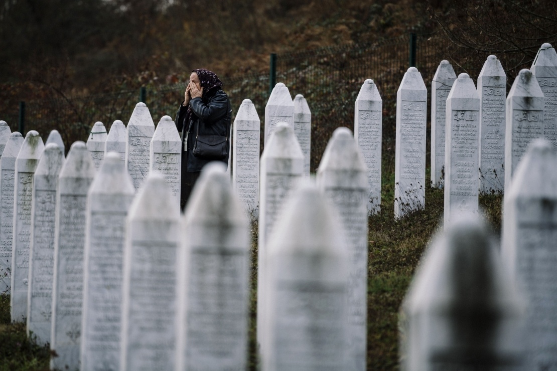A Bosnian woman cleans a freshly dug grave at the memorial cemetery in the village of Potocari near Srebrenica, July 8, 2010.