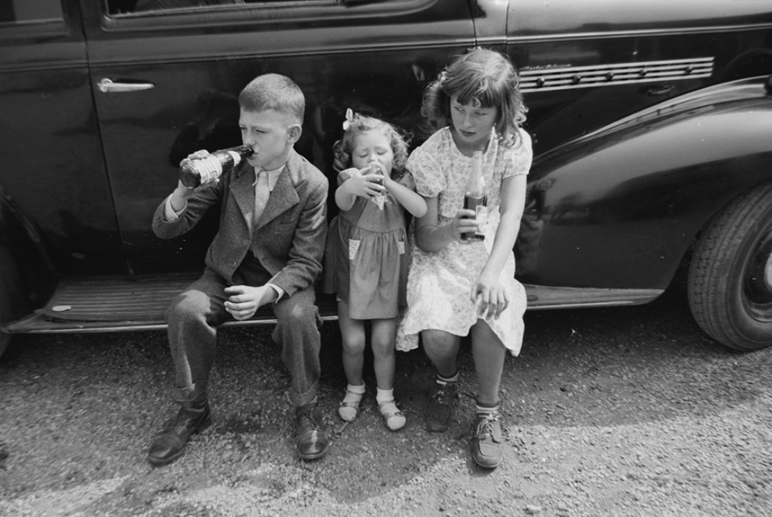 Американские дети сидят на подножке автомобиля и пьют Pepsi в 12-унцевых бутылках, 1939 год.
