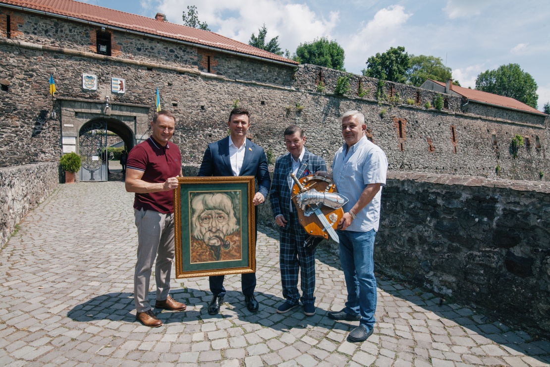 Николай Тищенко и депутат-мажоритарщик от СН Михаил Лаба принимают подарки у входа в Ужгородский замок.