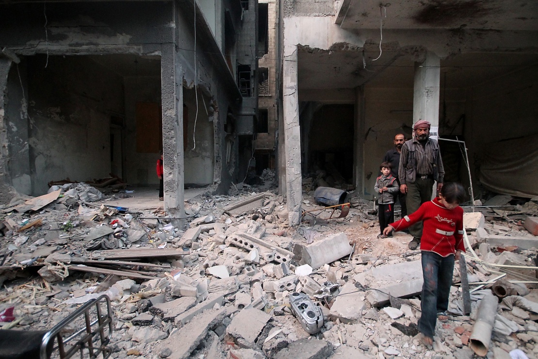 Жители Восточной Гуты среди обломков домов после авиаудара, Сирия, 18 октября 2014 года.