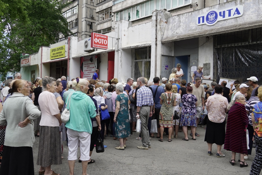 Pensioners line up outside a post office to collect their monthly payments in Mariupol, July 18, 2022.