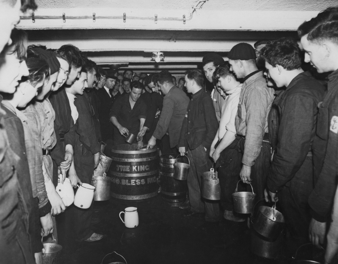 British naval sailors receive their daily ration of rum aboard an aircraft carrier in the Atlantic Ocean, June 30, 1942.