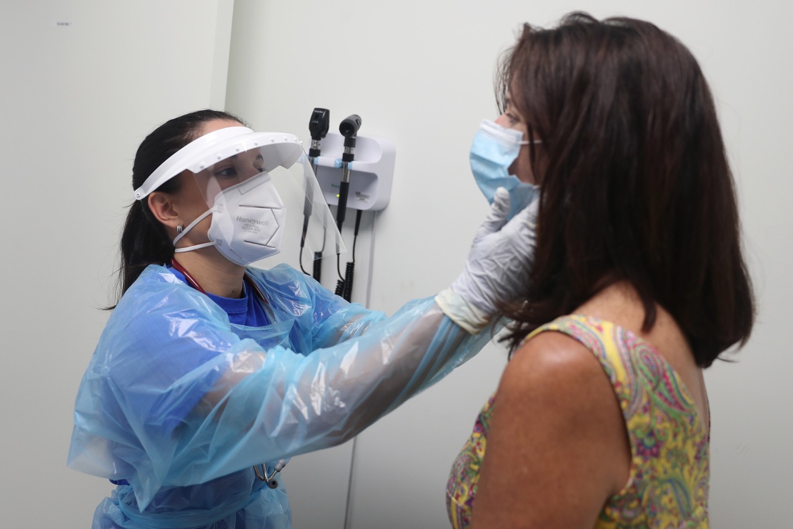 Медсестра осматривает женщину, которая участвовала в клинических испытаниях вакцины от коронавируса. Голливуд, 7 августа 2020 года.