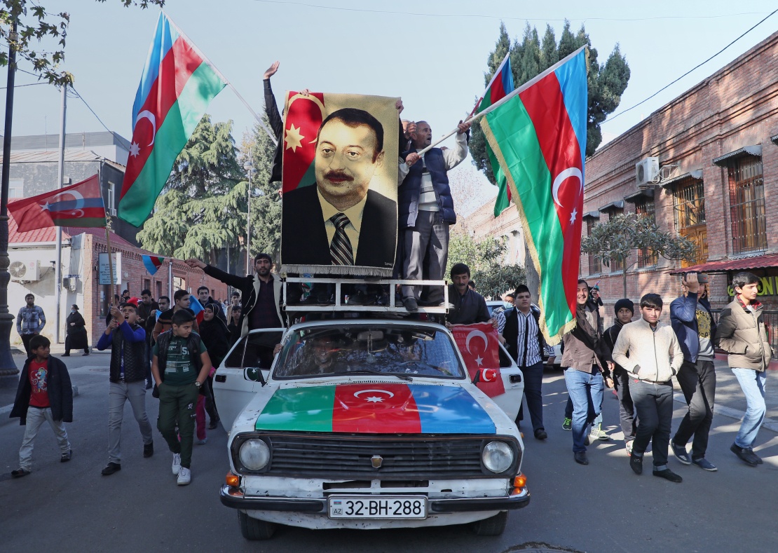 Жителі азербайджанського міста Гянджа з національними прапорами і портретом президента Ільхама Алієва святкують завершення конфлікту у Нагірному Карабаху, 10 листопада 2020 року.