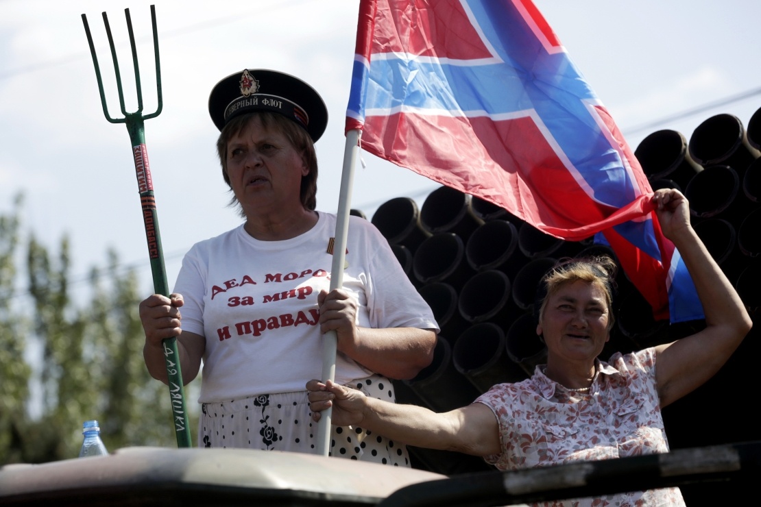 A woman rides on a truckʼs body with a pitchfork and the flag of "Novorossiya" during the "parade of prisoners".  Donetsk, August 24, 2014.