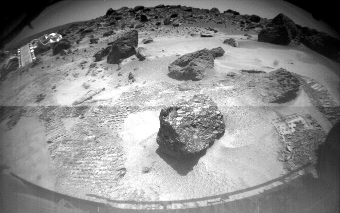 Фото марсианской поверхности, сделанное ровером Sojourner. На заднем плане — посадочный аппарат Mars Pathfinder. 10 июля 1997 года.