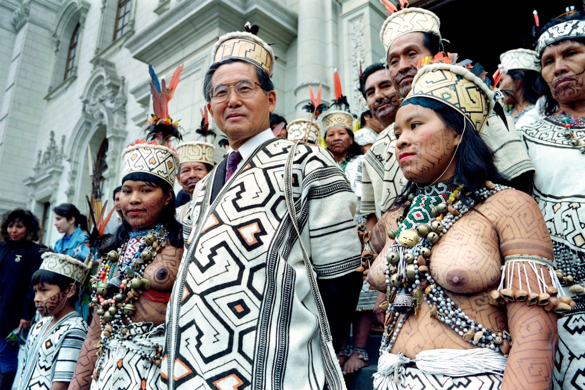 Перуанский президент Альберто Фухимори позирует в традиционной одежде племен Амазонии рядом с коренными жителями Перу, 10 сентября 1992 года.