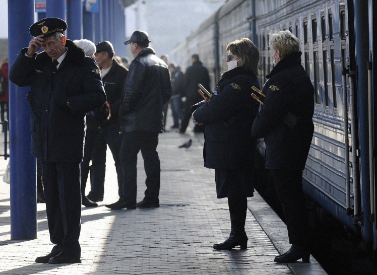 Проводницы в марлевых повязках стоят на перроне перед отправлением поезда Севастополь — Киев, 14 декабря 2009 года.