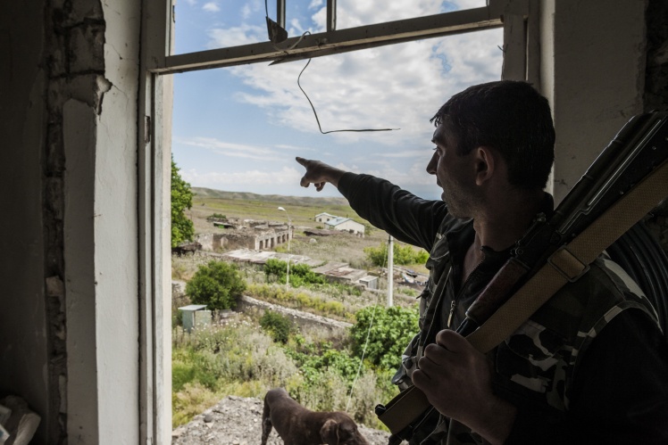 Солдат Нагорного Карабаха в селе Талыш 2 июня 2017 года указывает на позиции азербайджанской армии на расстоянии одного километра.