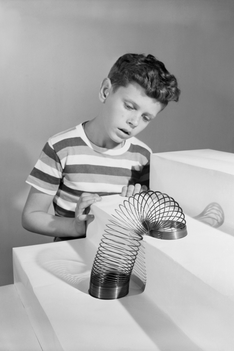 Хлопчик спостерігає, як іграшкова пружинка Slinky «спускається» сходами, 1946 рік.