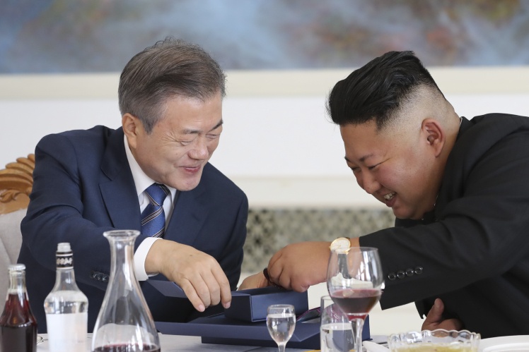 Президент Південної Кореї Мун Чже Ін (ліворуч) розмовляє з лідером Північної Кореї Кім Чен Ином (праворуч) під час обіду в ресторані 19 вересня 2018 року. Тоді відбулась зустріч на міжкорейському саміті, де вони обговорювали шляхи денуклеаризації Корейського півострова.
