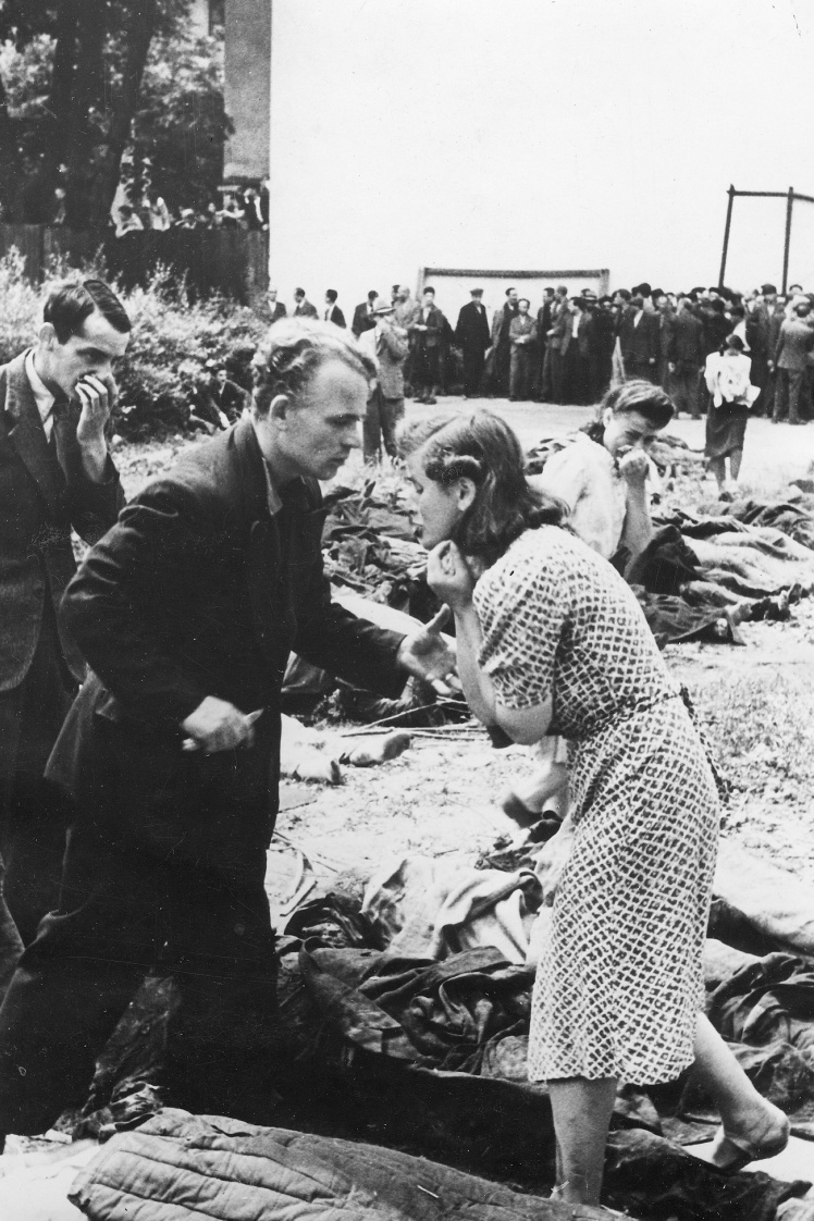 Ukrainians search for the bodies of relatives in the yard of a prison in Lviv, July 1943.