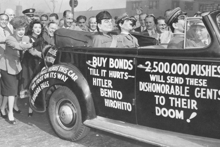 Рекламна кампанія військових облігацій у США. Усередині автомобіля — ляльки німецького та італійського диктаторів Гітлера і Муссоліні, а також японського імператора Хірохіто. Автомобіль зрештою скинули з Ніагарського водоспаду, 1 вересня 1942 року.