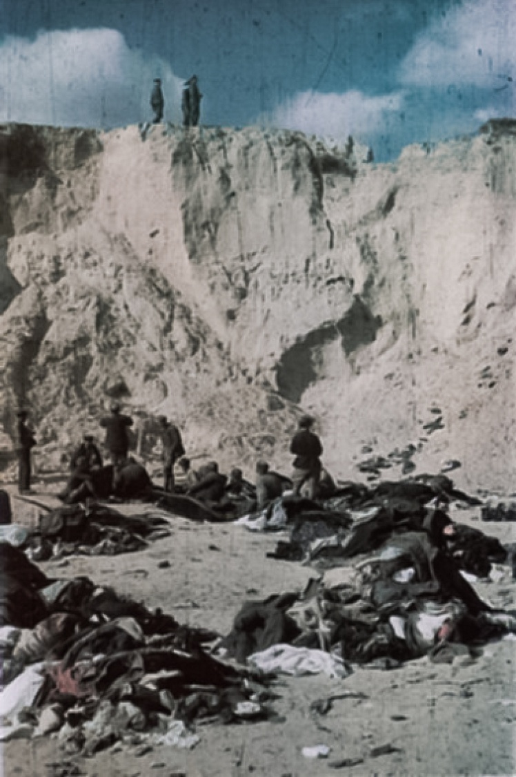 Немецкие солдаты (сверху урочища) привели советских военнопленных (внизу) засыпать тела расстрелянных евреев. На фото те стоят среди вещей погибших.