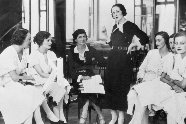 Coco Chanel (seated in the center) in her fashion salon in London, 1932.