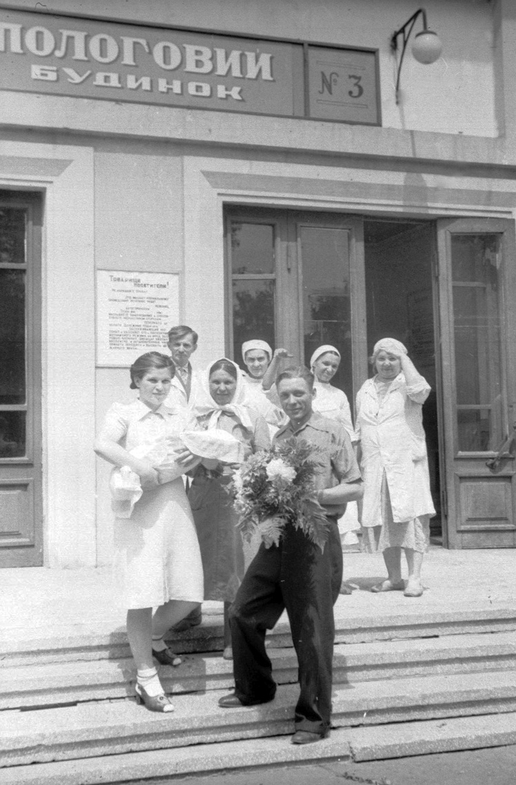 І. Омельченко виходить з пологового будинку № 3 з дитиною на руках, Київ, 1946 рік.