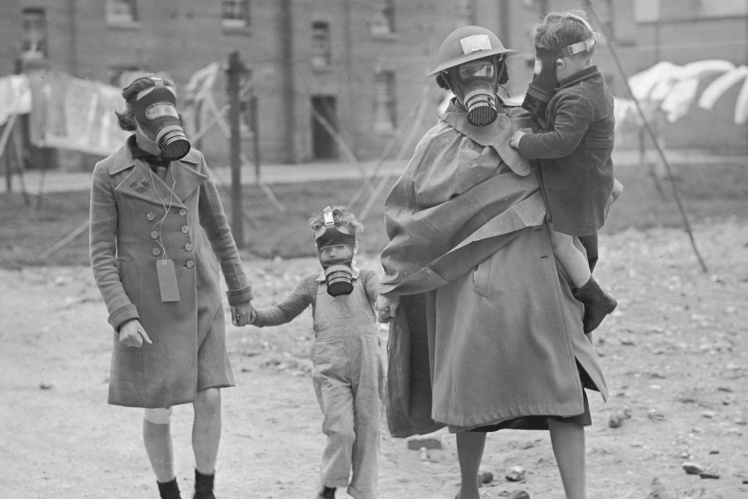 A woman with a girl and two little boys goes to a bomb shelter during an exercise in the south of England, 1939.