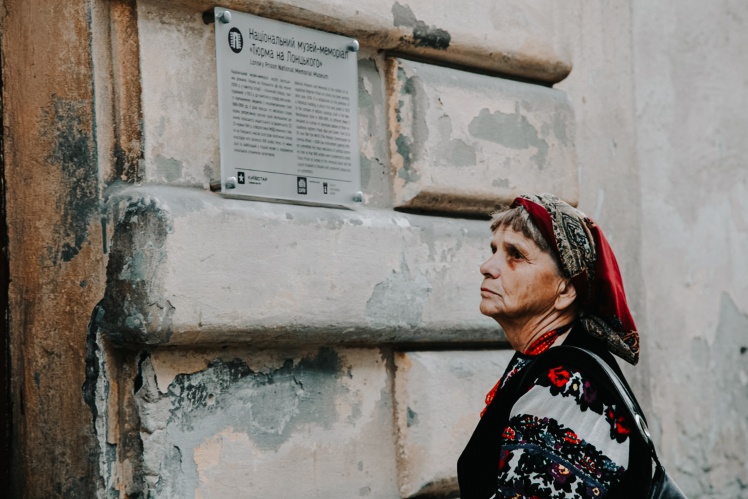 A woman in front of the entrance to the Lontsky Prison Memorial Museum.