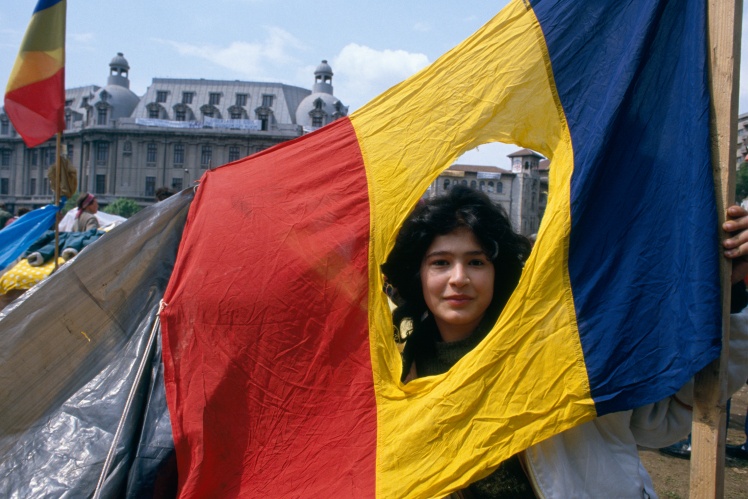 Во время протестов в Бухаресте в 1989 году демонстранты вырезали из центральной части румынского флага советский герб.