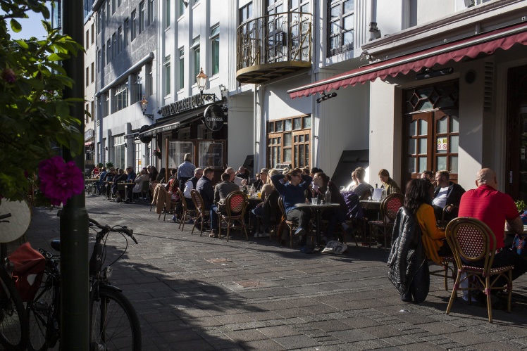 Клієнти сидять за столиками біля ресторанів і кафе у Рейк'явіку, 19 липня 2020 року.