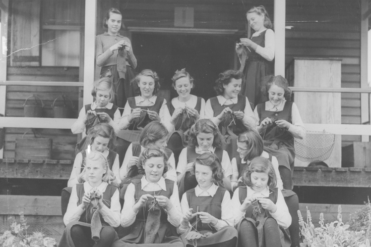 Евакуйовані британські школярки навчаються плести на уроці праці, 1943 рік.