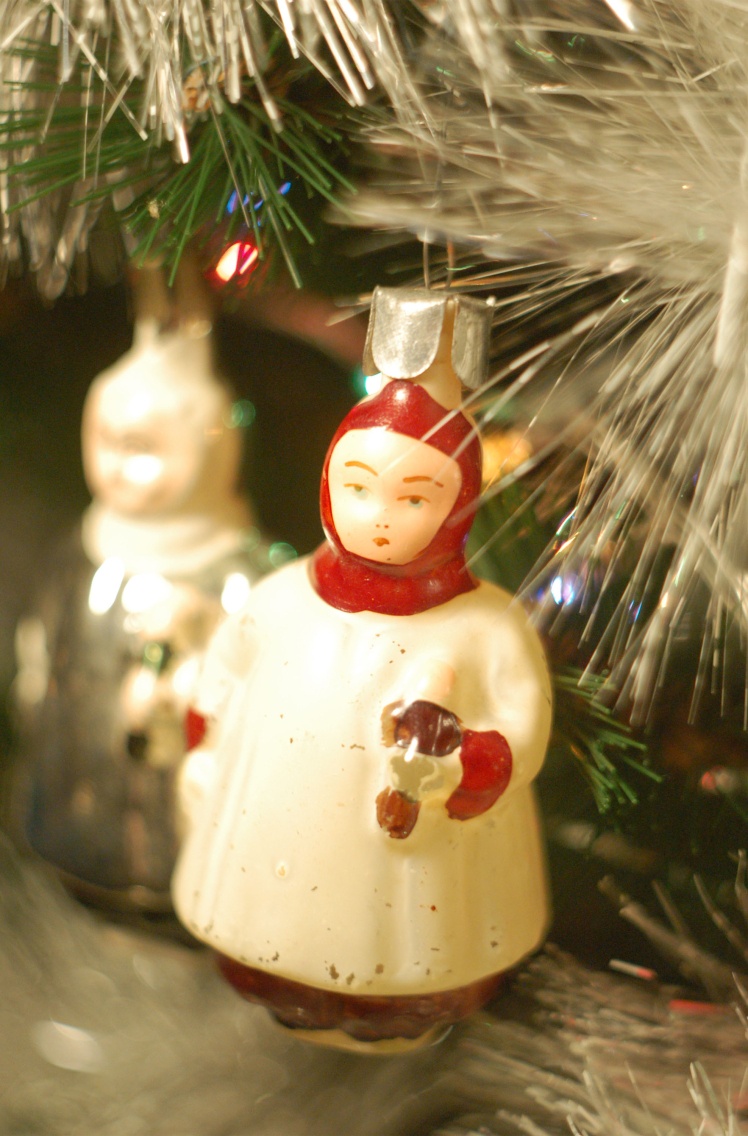Новорічна ялинкова іграшка «Дівчинка з лялькою» у біло-червоних кольорах.