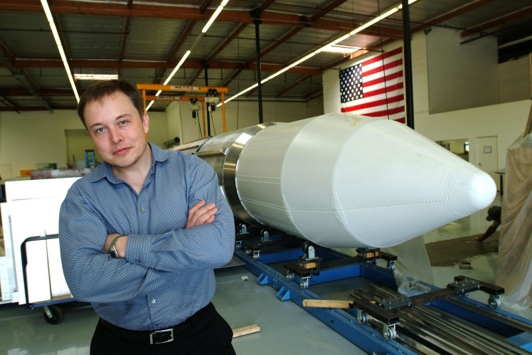 Ілон Маск позує біля ракети у офісі SpaceX.