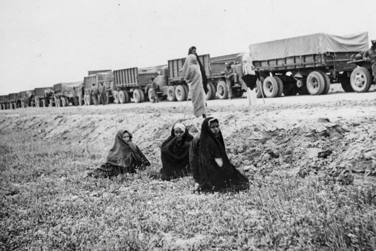 Iranian women watch a convoy of American trucks delivering a lease to the USSR on June 5, 1943.