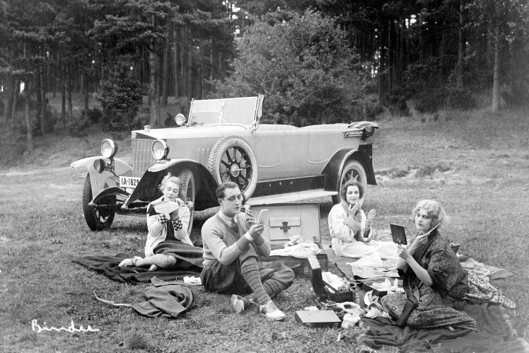 Women and men do makeup before returning home from a country trip for the weekend, 1927.