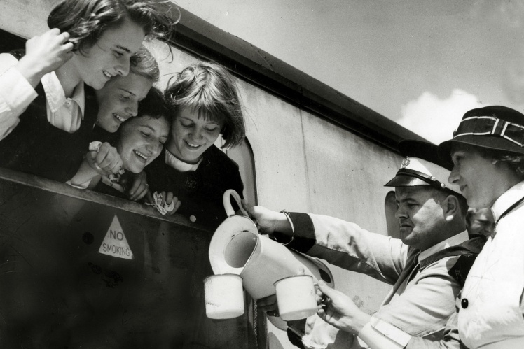 Працівники британської залізниці напувають дітей під час зупинки евакуаційного потяга, 1940 рік.
