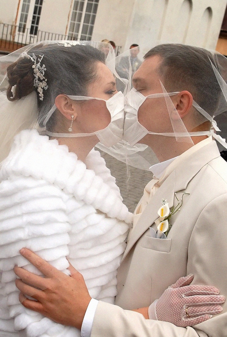 Молодожены Виктор и Наталья Ивановы целуются в респираторных масках во Львове, 7 ноября 2009 года.