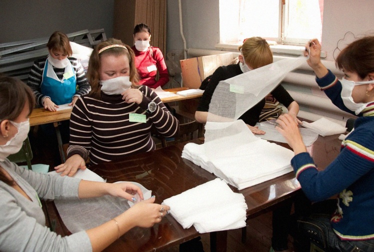 Учениці коледжу допомагають робити заготовки для марлевих повʼязок на швейному підприємстві в Запоріжжі, 2 листопада 2009 року.