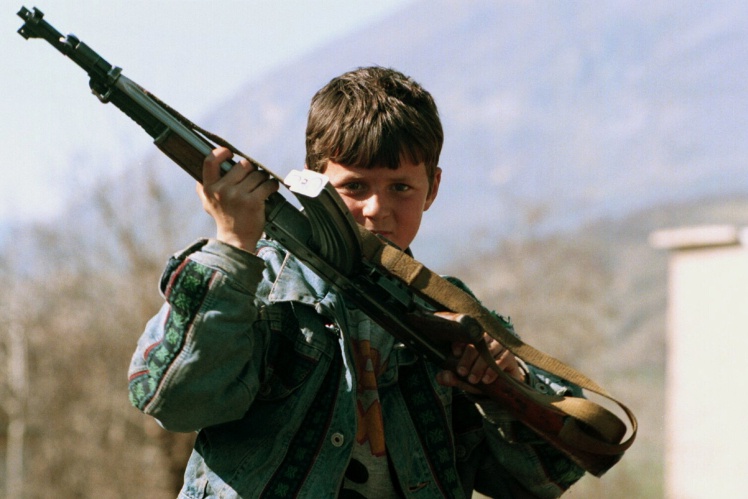 Мальчик с автоматом Калашникова во время конфликта на юге Албании, март 1997 года.