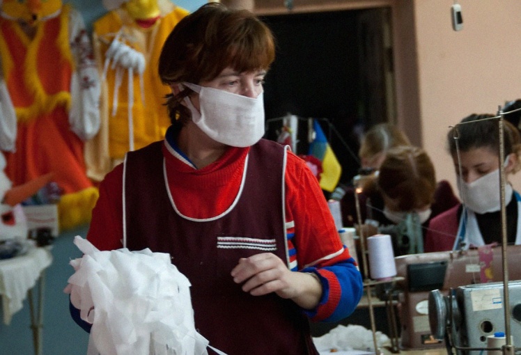 Співробітниця швейного підприємства в Запоріжжі готує матеріали для марлевих повʼязок, 2 листопада 2009 року.