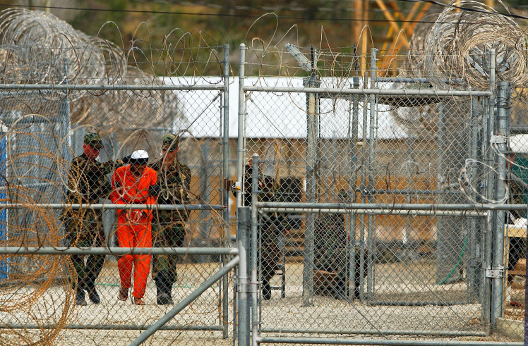 Військові супроводжують затриманого до його камери у Гуантанамо, Куба, 11 січня 2001  року.